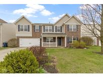 Charming two-story home with brick and vinyl siding, manicured lawn, and inviting front porch at 10955 Balfour Dr, Noblesville, IN 46060