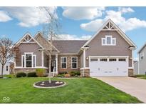 Charming home featuring stone accents, a two-car garage, and a well-manicured lawn at 13494 Moorcroft Dr, Fishers, IN 46037