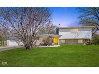 Charming home featuring a spacious front yard and a bright yellow front door at 1708 Fox Hill Dr, Indianapolis, IN 46228