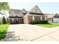 Inviting two-story brick home featuring a spacious driveway and attached garage at 4309 Summerhaven Dr, New Palestine, IN 46163