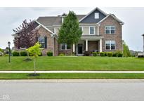Charming two-story brick home with a well-manicured lawn and inviting front porch with stylish accents at 4415 Voyageur Way, Carmel, IN 46074