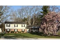 Charming two-story home with brick and vinyl siding, mature landscaping, and flowering tree at 6436 Lakeland Blvd, Indianapolis, IN 46234