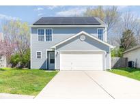 Charming home featuring solar panels, a two-car garage, and well-maintained landscaping at 7010 Beargrass Ct, Indianapolis, IN 46241