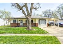 Charming ranch-style home with a well-manicured lawn, mature trees, and a covered carport at 739 Laurel Ln, Fortville, IN 46040