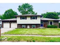Charming two-story home featuring a well-maintained lawn, attached two-car garage, and welcoming facade at 8616 Old Dominion Ct, Indianapolis, IN 46231