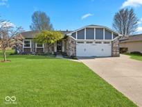 Charming single-story home with brick facade, manicured lawn, and two-car garage at 919 Oak Park Dr, Shelbyville, IN 46176