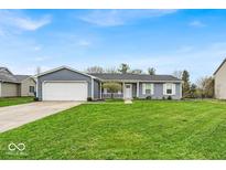 Charming single-story home with a well-manicured lawn and attached two-car garage at 9328 Haddington W Dr, Indianapolis, IN 46256