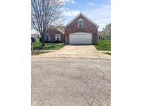 Charming brick home with a two-car garage and a concrete driveway at 11631 Tucker Ct, Indianapolis, IN 46229