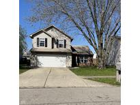 Two-story home featuring a front yard, driveway, and attached garage at 1231 Chesterfield Dr, Anderson, IN 46012