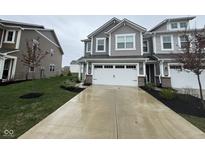 Charming gray two-story townhouse featuring a white two car garage and concrete driveway at 1268 Newton St, Avon, IN 46123