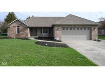 Charming brick home featuring an attached garage and a well-maintained lawn with black mulch at 16 Corkwood Ct, Brownsburg, IN 46112