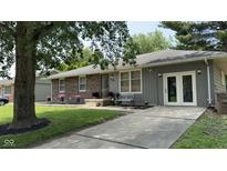 Charming home featuring a brick facade, gray siding, a well-manicured lawn, and mature trees at 2126 Dawnshire Dr, Columbus, IN 47203