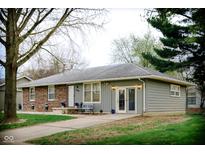 Charming single-story home featuring a brick facade, well-maintained lawn, and inviting front porch with seating at 2126 Dawnshire Dr, Columbus, IN 47203
