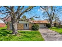 Charming single-story brick home with mature tree, green lawn, and driveway leading to attached garage at 2753 N High School Rd, Indianapolis, IN 46224