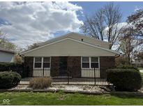 Charming single-story brick home with a black fence and well-maintained front yard on a sunny day at 3333 Lupine Dr, Indianapolis, IN 46224