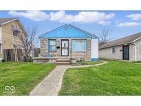 Charming single-story home with stone and siding, complemented by a well-manicured lawn and blue accents at 3924 E 30Th St, Indianapolis, IN 46218