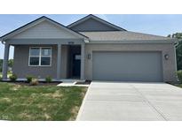 Charming single-story home featuring a grey brick facade, a well-manicured lawn, and a paved driveway at 3949 Donaldson Creek Ct, Clayton, IN 46118
