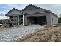 New construction home with stone brick exterior, attached garage and unfinished yard at 3949 Donaldson Creek Ct, Clayton, IN 46118
