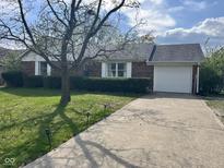Charming brick home with well-maintained landscaping and an attached one car garage at 7740 5 Points Rd, Indianapolis, IN 46259