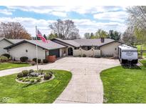 Charming single-story home with manicured lawn, circular driveway, and American flag at 1153 Diablo Rd, Greenwood, IN 46143