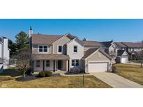 Charming two-story home with a brick and siding exterior, attached garage, and manicured lawn at 12332 Cobblefield Ct, Fishers, IN 46037