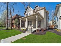 Charming home boasts a welcoming front porch and professionally landscaped yard at 1818 Central Ave, Indianapolis, IN 46202