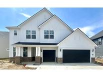 New construction home boasts a white exterior with a three-car garage and charming architectural details at 18944 Seaforth Way, Westfield, IN 46074