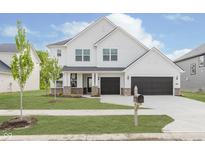 Stunning two-story white home featuring a two-car garage and well-manicured lawn with young tree at 18944 Seaforth Way, Westfield, IN 46074