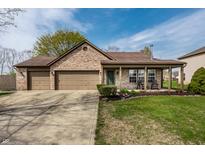 Charming brick home featuring a two-car garage, covered porch, and well-maintained lawn at 2034 Milburn Dr, Brownsburg, IN 46112