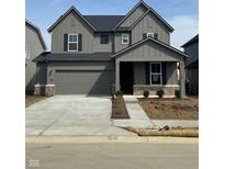 Two-story home featuring a two-car garage, dark shutters, and stone accents at 2741 Penn Ave, Plainfield, IN 46168