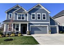Charming two-story home featuring a well-manicured lawn and a spacious two-car garage with an attached single car garage at 5300 Veranda Dr, Noblesville, IN 46062