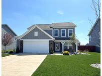 Charming two-story home with a well-manicured lawn, attached garage, and inviting front entrance at 5493 W Woodhaven Dr, McCordsville, IN 46055