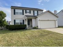 Charming two-story home with green shutters, landscaped yard, and attached two car garage at 5663 Rains Ln, Indianapolis, IN 46254
