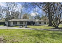Classic ranch home with a long, paved driveway, complemented by a lush, green lawn at 6025 Crows Nest Dr, Indianapolis, IN 46228
