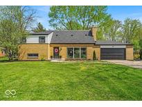 Charming brick home featuring a well-manicured lawn and attached garage, perfect for comfortable suburban living at 7205 Steven Ln, Indianapolis, IN 46260