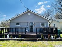 Charming home featuring a lovely front deck, gray siding, and well-maintained landscaping at 1117 Hendricks Ave, Shelbyville, IN 46176