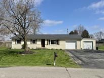 Charming one-story home featuring an attached garage, large front yard, and mature tree, a classic suburban retreat at 1210 W Grant St, Thorntown, IN 46071