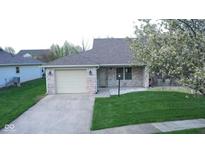 Charming single-story home with brick facade, attached garage, front lawn, and blooming tree at 1366 Swan Dr, Franklin, IN 46131