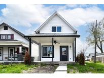 Charming home features a covered porch, black trim, and manicured landscaping at 1814 New St, Indianapolis, IN 46203