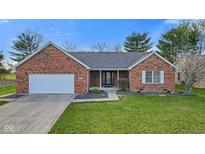Charming red brick home with a well-manicured lawn, a two-car garage, and a welcoming front entrance at 2511 Countryside Westview Dr, Shelbyville, IN 46176