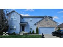 Charming two-story home featuring a mix of siding and brick, a two-car garage, and manicured landscaping at 3180 Winings Ln, Carmel, IN 46074