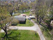 Aerial view of a charming home with a well-maintained yard and a pond in a serene neighborhood at 3311 Stella St, Greenwood, IN 46143