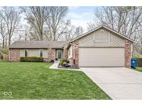 Charming single-story home featuring brick and siding exterior, well-manicured lawn, and attached two-car garage at 334 Stonehedge Dr, Carmel, IN 46032