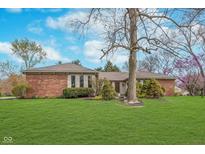 Charming brick ranch home featuring mature trees and a lush green lawn at 3462 Briar Creek Ln, Carmel, IN 46033