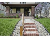 Inviting front porch with brick pillars and steps leading to the entrance, surrounded by a lush lawn at 40 N Ritter Ave, Indianapolis, IN 46219