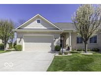 Charming single-story home featuring a well-manicured lawn, attached garage, and beautiful blossoming trees under a clear blue sky at 537 Weyworth Pl, Greenwood, IN 46142