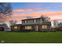Charming two-story home featuring a covered front porch and a spacious green lawn at 5831 Bar Del W Dr, Indianapolis, IN 46221