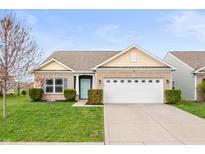 Charming brick home with a well-maintained lawn and two-car garage in a suburban neighborhood at 6323 Emerald Field Way, Indianapolis, IN 46221