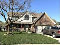 Charming two-story home with a brick and siding facade, attached garage, and well-maintained front yard at 7354 Samuel Dr, Indianapolis, IN 46259