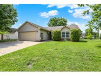 Charming single-story home with an attached two car garage and a well-maintained lawn at 902 Helm Dr, Avon, IN 46123